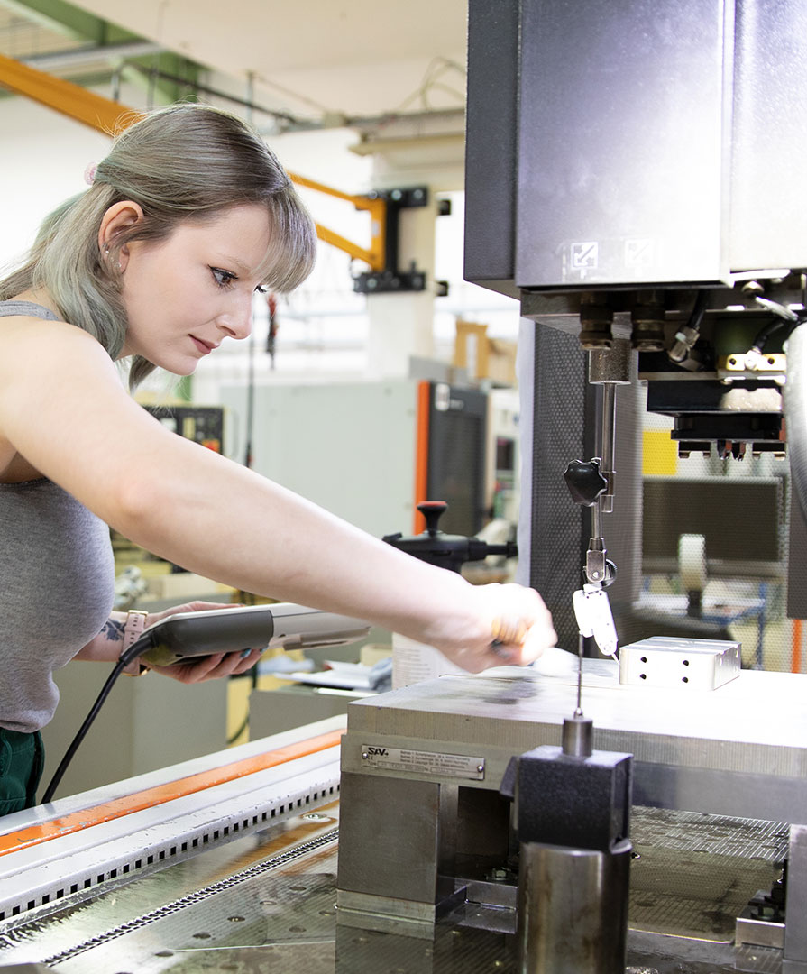 Unsere Auszubildende Werkzeugmechanikerin an der Maschine.